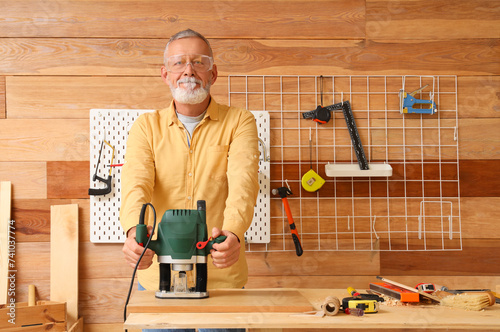 Mature carpenter working wi...