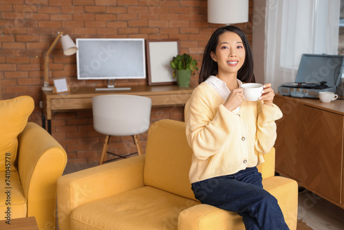 Young Asian woman with coff...