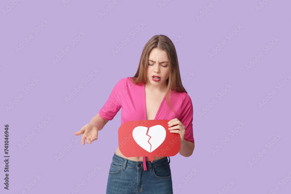 Beautiful young displeased woman with heart dislike icon on purple background Beautiful young displeased woman with heart dislike icon on purple background