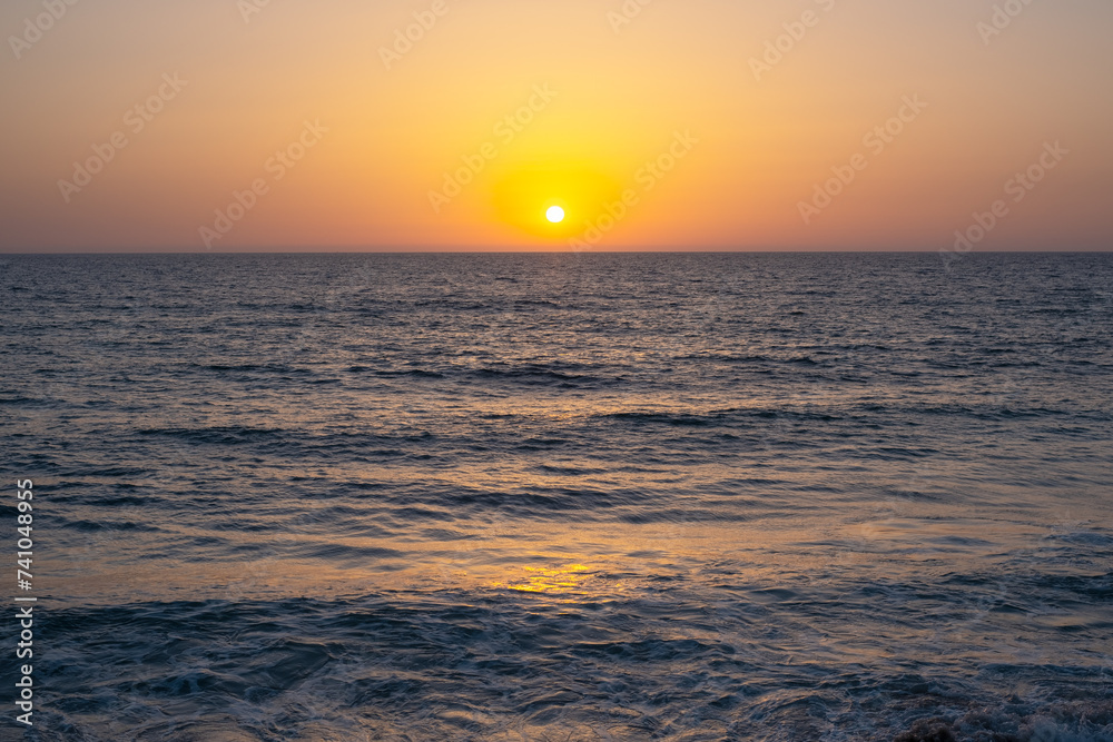 sun sets sky over the Mediterranean Sea horizon with a warm, golden glow. The sea's waves magical tranquil seascape sun sets sky over the Mediterranean Sea horizon with a warm, golden glow. The sea's waves magical tranquil seascape