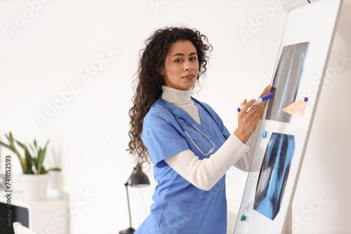 Female African-American medical intern with x-ray images in clinic