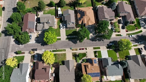 Suburban low density housing single family homes in average middle class neighborhood. Drone shot slowly trucking right down street.