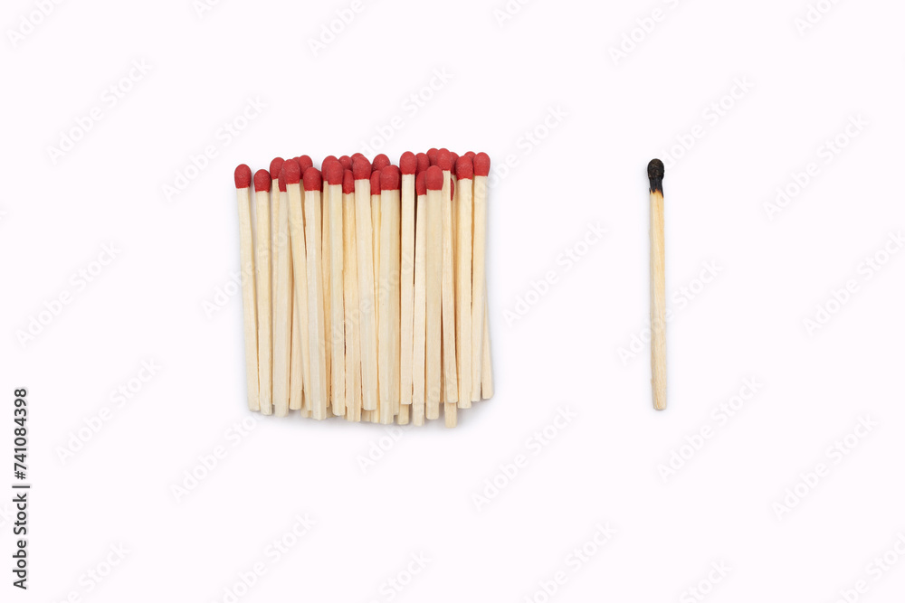 Red matches together and one burnt one isolated on a white background. Matches without a matchbox. Burnt match next to new matches on white with space for text