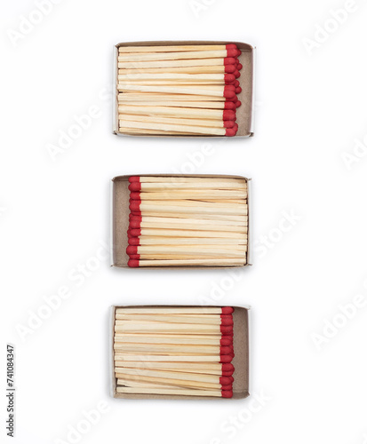 Close-up of matches in matchboxes. Three open cardboard matchboxes filled with matches on a white background. Top view of matches close-up with space for text. Matchboxes isolated on white background