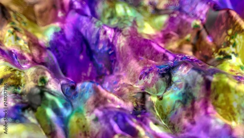 Vibrant, colorful, fluid and wavy abstract paint seamless loop animation. Modern and contemporary style in 4K with shades of magenta, purple, pink, yellow, green