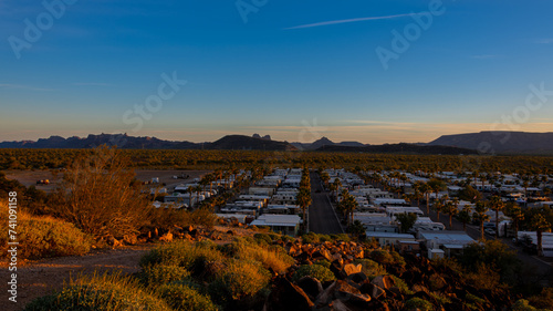 Arizona sunset above Rv park in the desert with mountains and blue skies