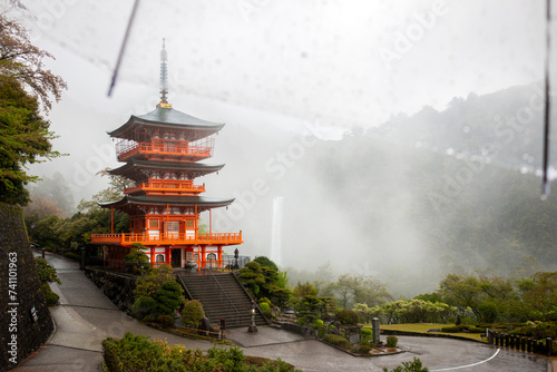 Seiganto-ji Temple Pagoda with Nachi Falls behind it on a rainy day, April, Japan