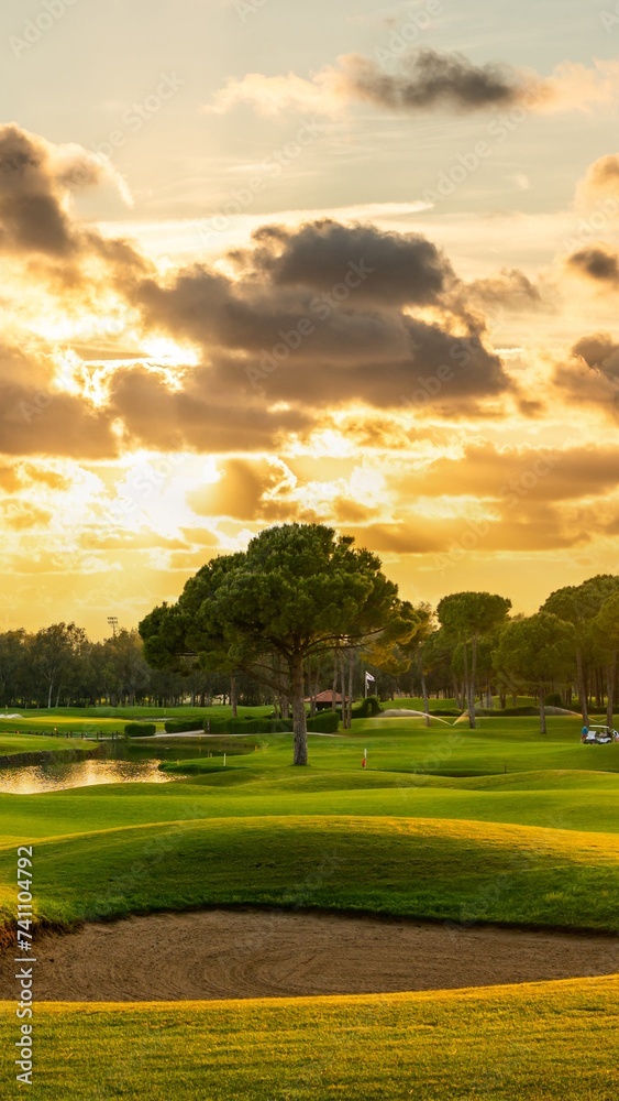 Panorama Golf course with a sand bunker in the center. Dramatic clouds in the sky during sunset Belek Turkey Panorama Golf course with a sand bunker in the center. Dramatic clouds in the sky during sunset Belek Turkey