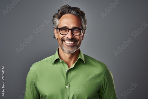 Happy smiling middle-aged businessman Confident professional businessman wearing colored shirt on gray background Advertising glasses lenses © ORG