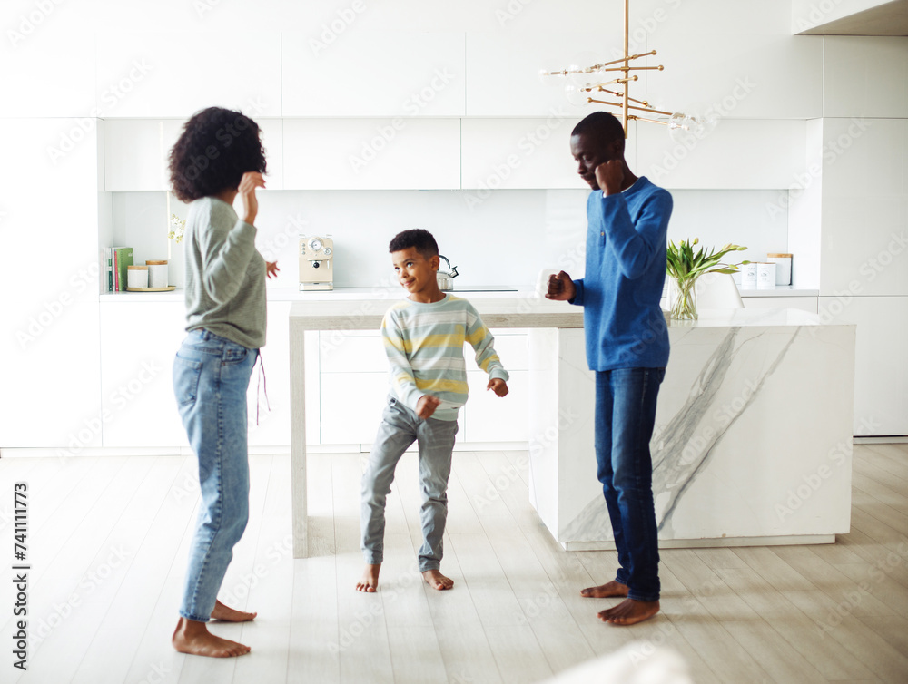 Fototapeta premium Cheerful afro american family - mom, dad and son dancing at home. Happy together.