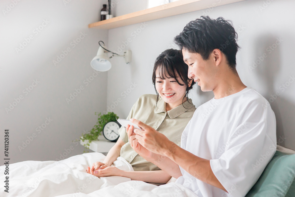 寝室・ベッドルームでスマホ・スマートフォンを使うアジア人夫婦・カップル・恋人・家族
寝室・ベッドルームでスマホ・スマートフォンを使うアジア人夫婦・カップル・恋人・家族