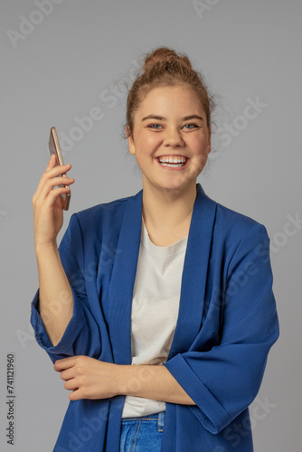 Vertical image of a happy girl with a cell phone in her hands