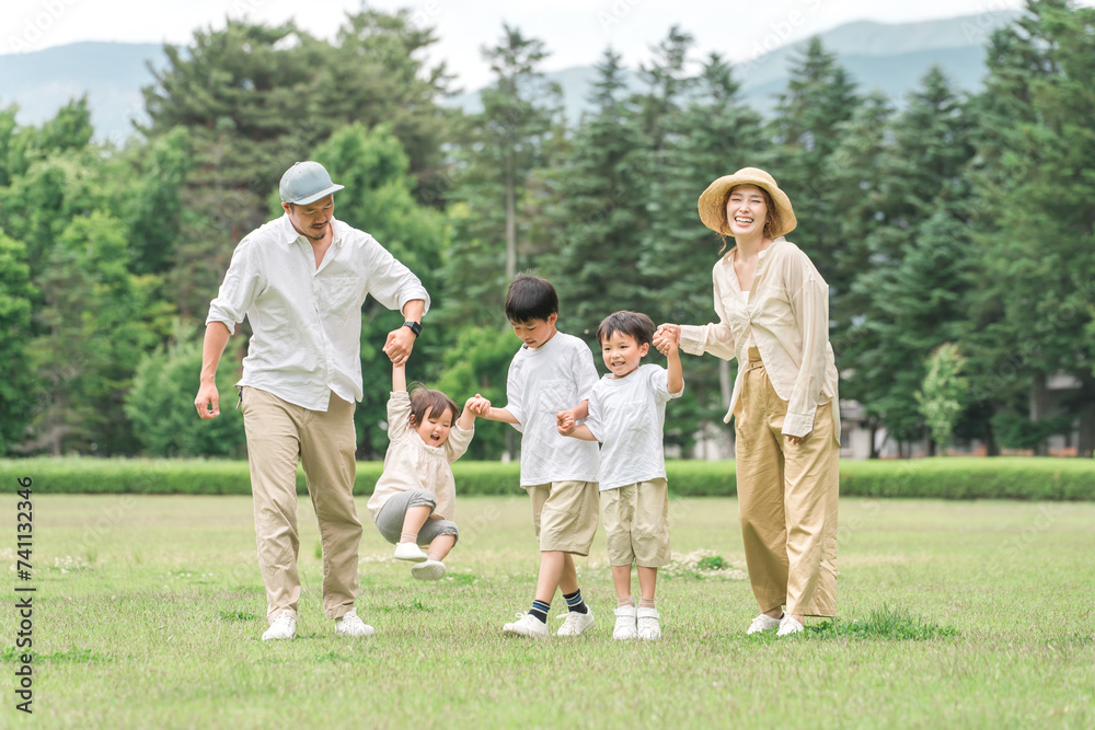 Fototapeta premium 夏休みに公園を手を繋いで歩く家族・ファミリー（レジャー・アウトドア・ピクニック・キャンプ・思い出） 