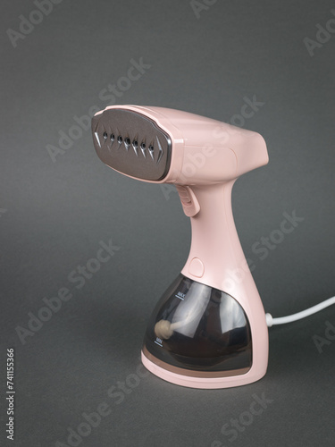 Schilderij op canvas Light pink steamer for clothes on a gray background.