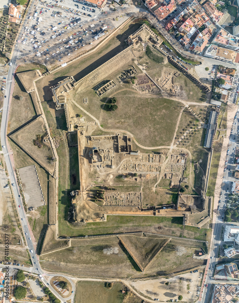 Panoramic aerial view of Roses citadel in Spain , giant pentagonal star fort fortress with bastions on each angle, ruins of medieval city, Roman ruins, monastery on the courtyard