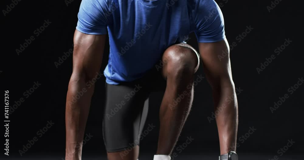African American athlete in starting position on a black background