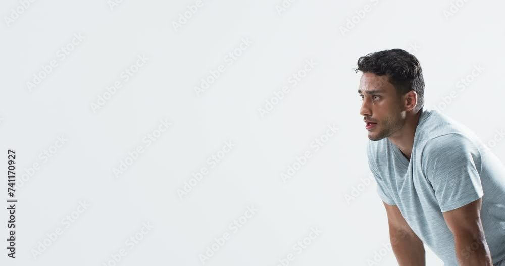 Young biracial man athlete focused during a throwing session on a white background, with copy space Young biracial man athlete focused during a throwing session on a white background, with copy space