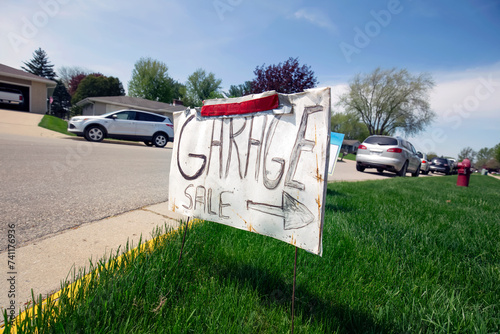 Garage sale sign on the lawn of a suburban home photo