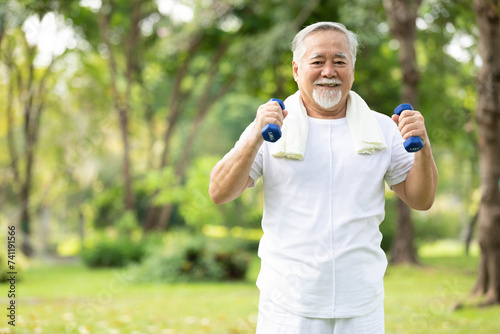 senior man exercising and lifting dumbbells in the park