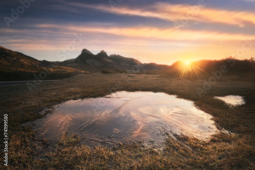 landscape at dawn in Lunada, Burgos, with the reflection of the sky in a frozen puddle photo