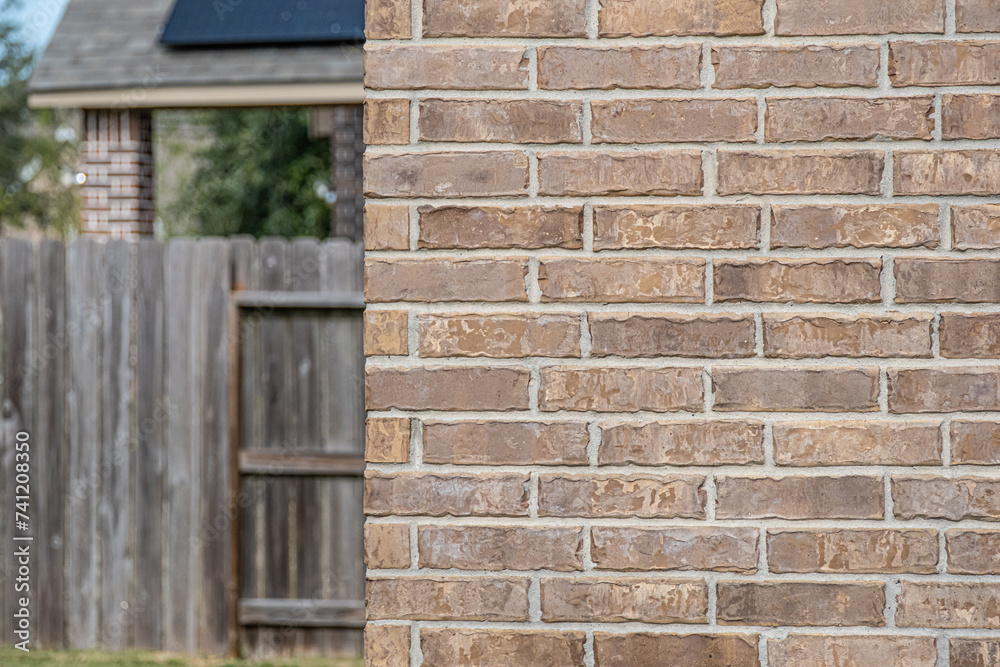 Red brick wall with fence in background Red brick wall with fence in background