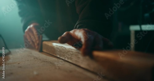 Sanding down the surface of a wooden plank to get it ready for painting photo
