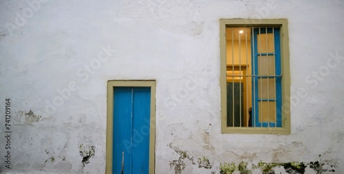 old vintage wooden door and window with old vintage white crack wall