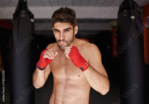 Boxer, man and portrait for fitness, exercise and wellness in strong training for confidence to fight. Gym, sport and boxing athlete in workout, challenge and shirtless ready to punch for mma © M Moller/peopleimages.com