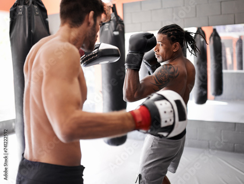 Men, training for boxing and fitness, sport and coaching with athlete and personal trainer for workout in gym. Exercise, skill and kickboxing with boxer team practice, MMA and challenge with action