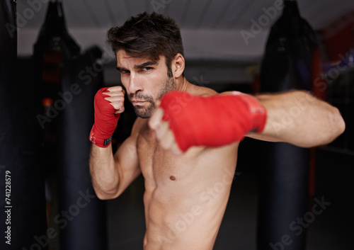 Man, portrait and ready for boxing or fight, fitness and topless for exercise and workout. Male person, bodybuilder and punching bag for challenge or practice, training and serious for competition