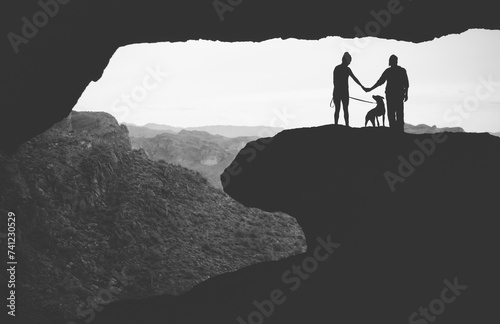 Silhouette of a hiking couple with their dog