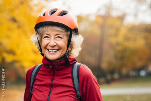 smiling senior woman in helmet and sportswear in autumn park
