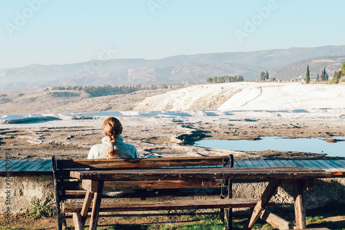 Rear view of Woman Sitting Alone Enjoying Mountain View Under The Blue Sky 