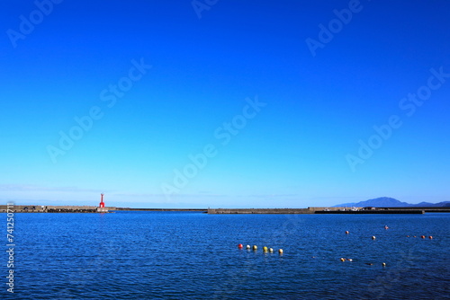 赤い灯台と小さな漁港 © 写真小僧