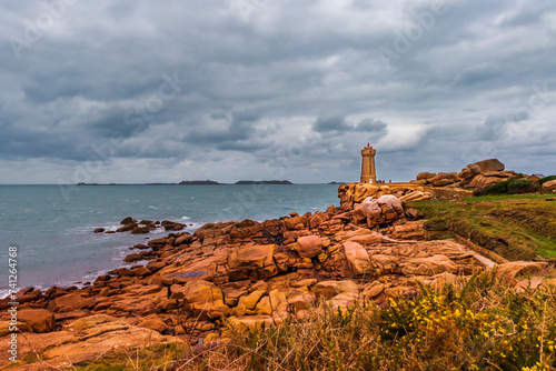 View of the famous lighthouse of Ploumanach near Perros Guirec, built of pink granite. It is a must-see building to visit in the area. photo