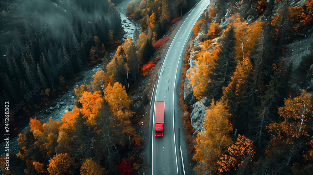 Aerial view of red truck driving on the road in autumn forest
