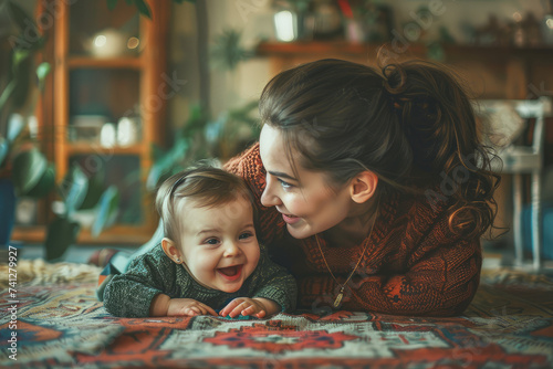 Side view of mother playing with laughing baby girl lying on her knees spending time at home
