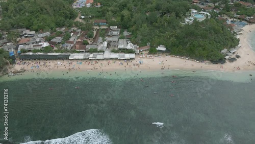 Exotic sandy beach with many people on warm cloudy day, aerial view photo