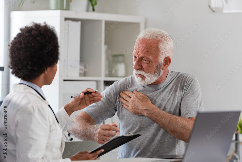 An African-American woman doctor specialist consults with an elderly male patient in her office An African-American woman doctor specialist consults with an elderly male patient in her office