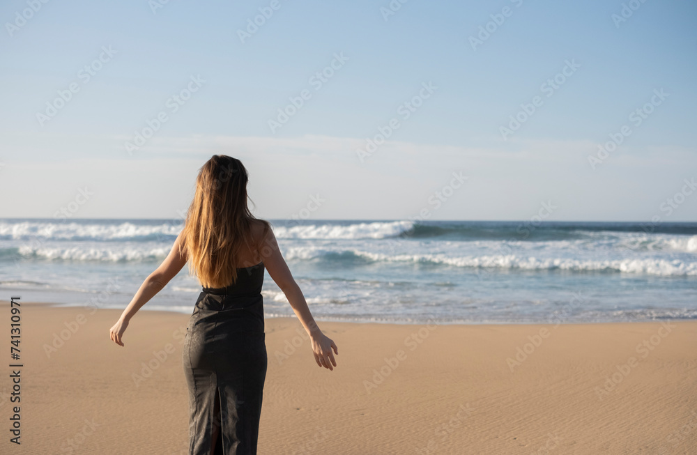 Mujer posando de espaldas en la playa