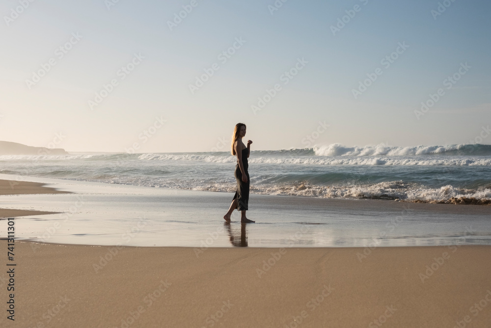 Mujer caminando por la arena junto el Océano, Fuerteventura. Instante mágico y único. Verano, calor, oleaje.