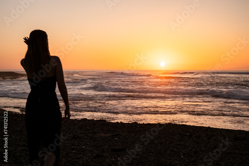 chica mirando puesta del sol en la playa de Fuerteventura