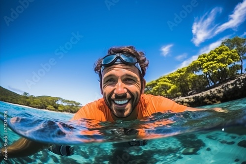Portrait of happy man in swimsuit with surfboard in water © Nerea