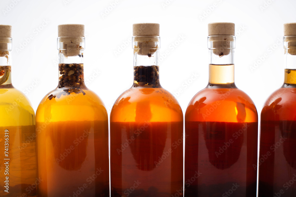 Many bottles with brown transparent alcoholic drink. Homemade tinctures based on natural herbs. Liquor and traditional vodka, collection Many bottles with brown transparent alcoholic drink. Homemade tinctures based on natural herbs. Liquor and traditional vodka, collection