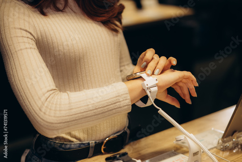 a woman buys a smart watch in an electronics store photo