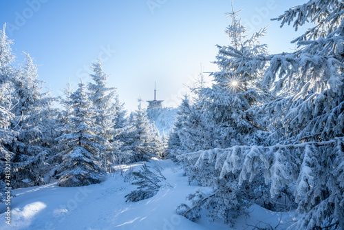 Snowy winter landscape with peak of Lysa mountain with transmitter, foot path and sun with sun rays. Beskydy, Czech Republic photo