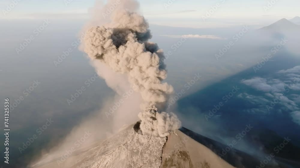 Drone shot of Fuego volcano in Guatemala erupting during beautiful sunrise