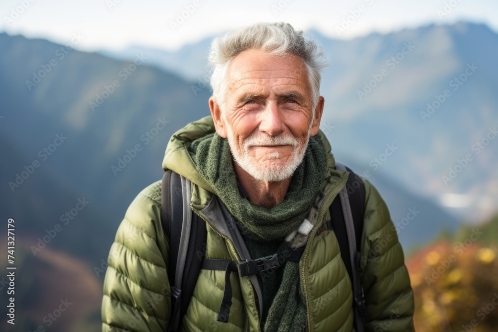 Portrait of a senior man with a backpack on the background of the mountains