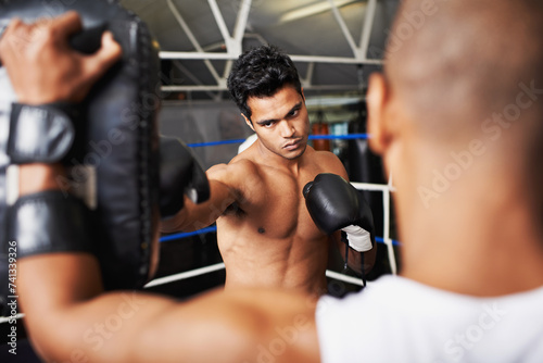 Boxer, man and coach in boxing ring with punching bag for training, workout and performance with fight or fitness. Professional, athlete and exercise for competition, match or sport with healthy body
