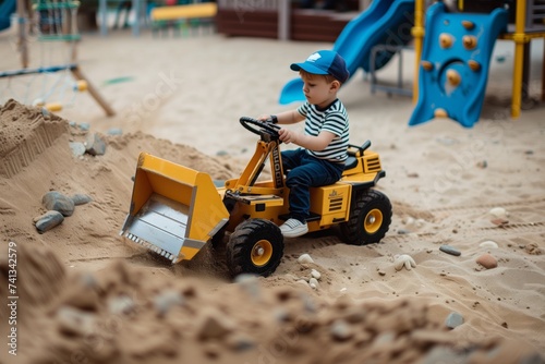 kid operating a digger in a playground sandpit